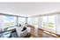 Couple with coffee mugs enjoying scenic views out the large windows at Seascape at Weymouth