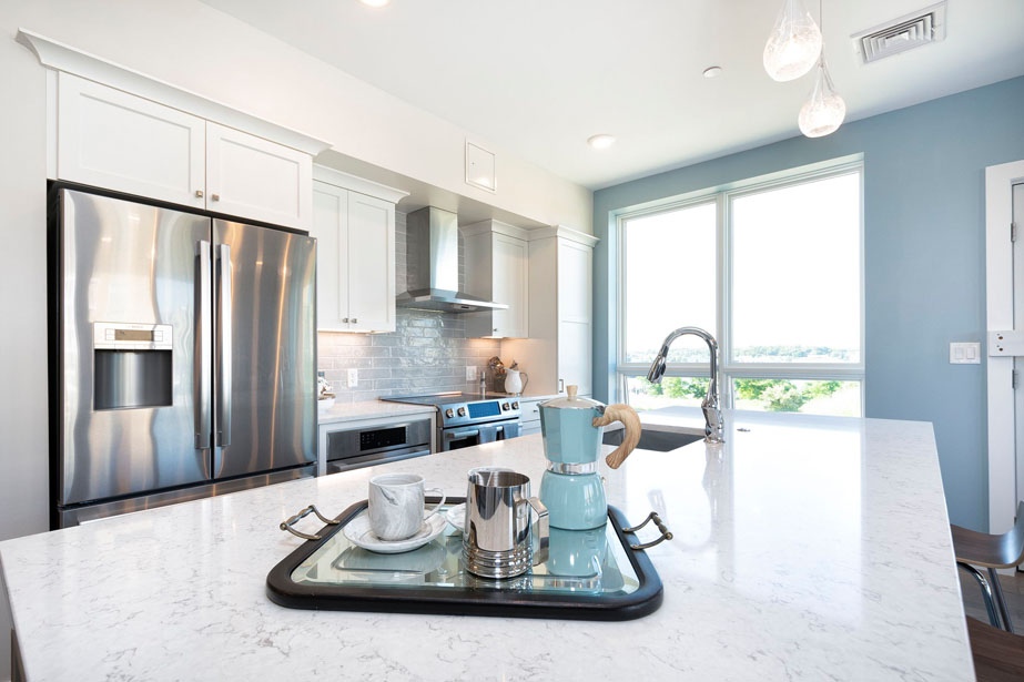 Couple with coffee mugs enjoying scenic views out the large windows at Seascape at Weymouth