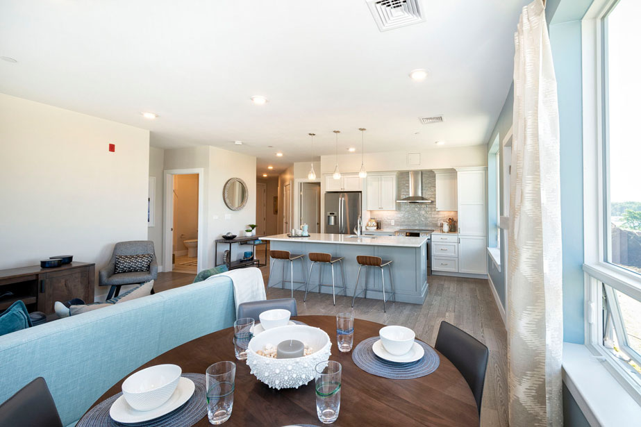 Couple with coffee mugs enjoying scenic views out the large windows at Seascape at Weymouth