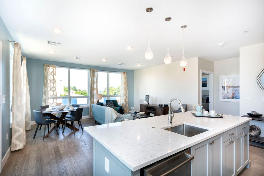 Couple with coffee mugs enjoying scenic views out the large windows at Seascape at Weymouth