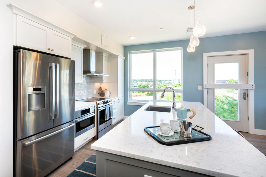Couple with coffee mugs enjoying scenic views out the large windows at Seascape at Weymouth