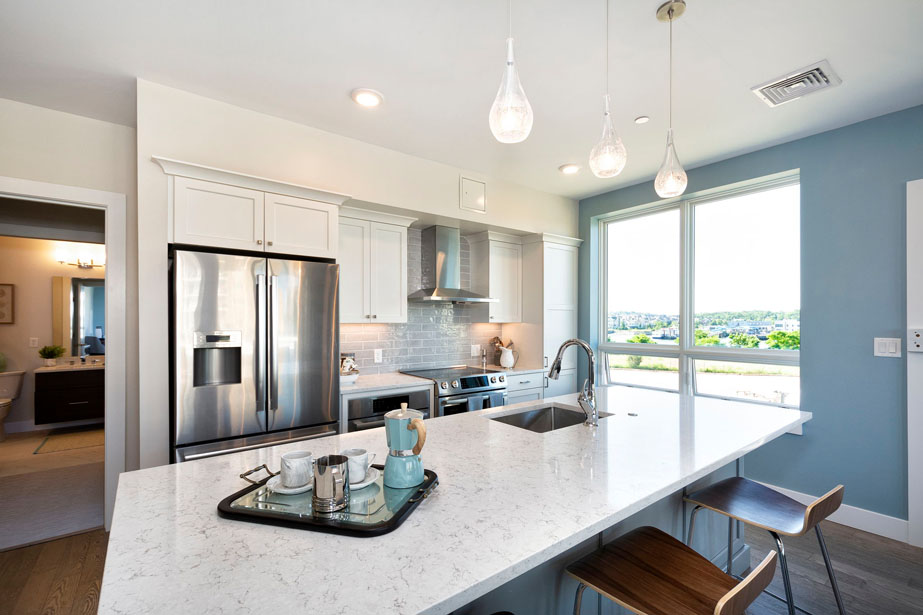 Couple with coffee mugs enjoying scenic views out the large windows at Seascape at Weymouth