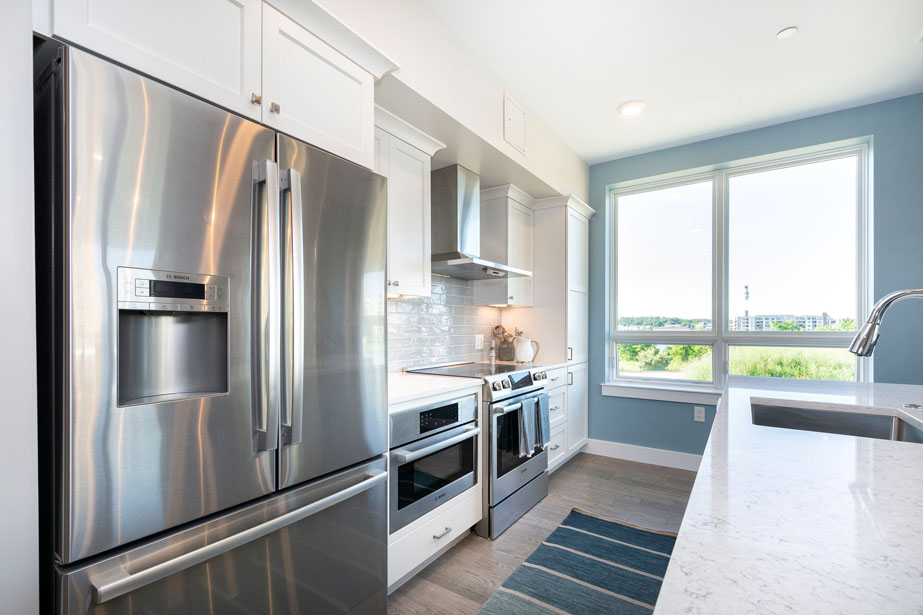 Couple with coffee mugs enjoying scenic views out the large windows at Seascape at Weymouth